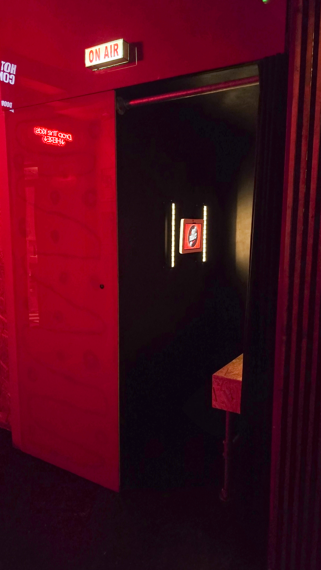 'On Air' photo booth doorway with red neon