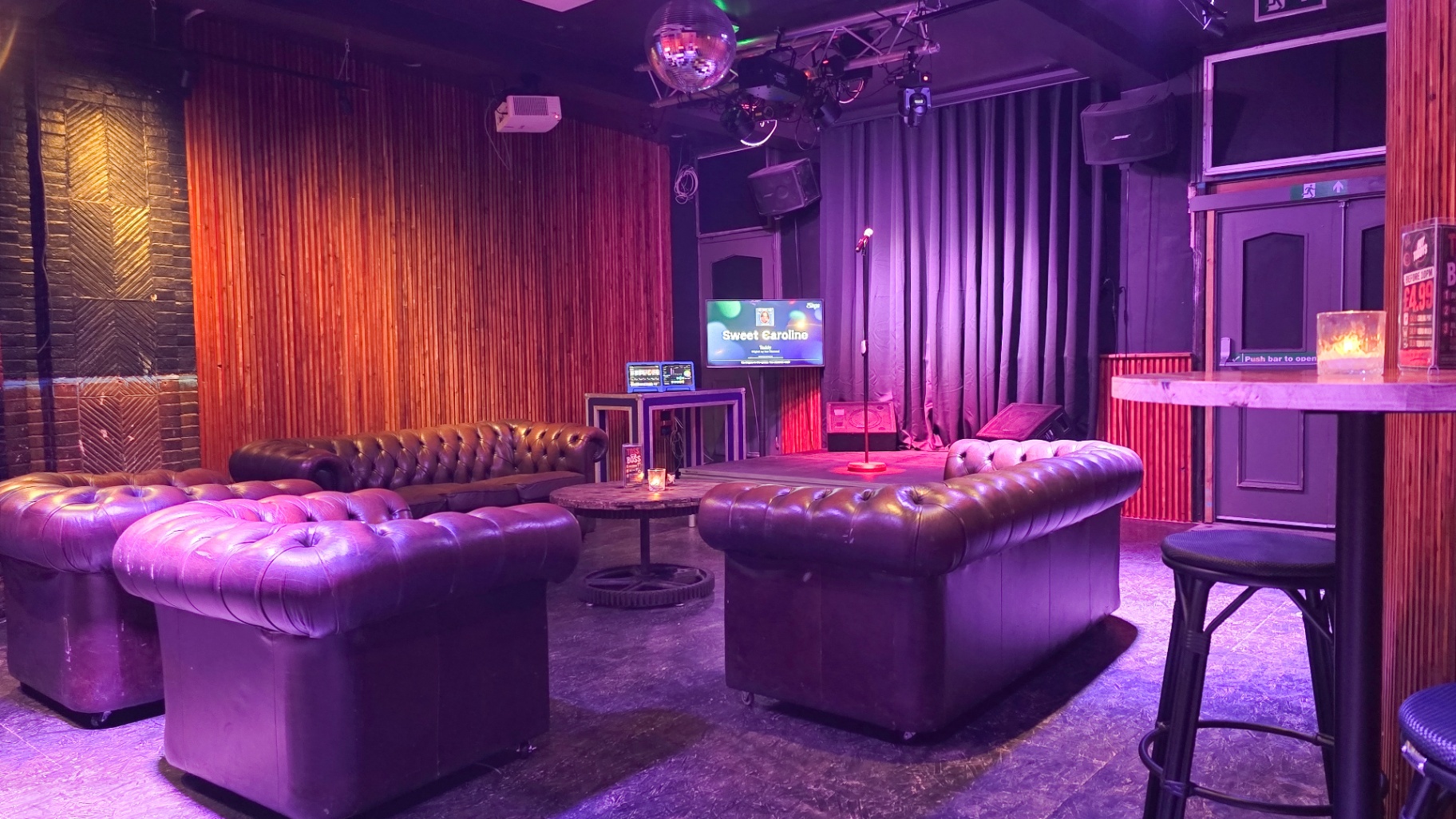 Purple-lit lounge area with plush seating