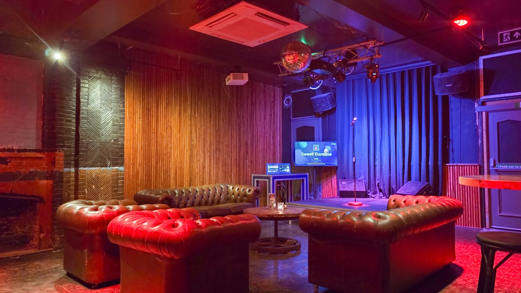Karaoke lounge with Chesterfields, disco ball and stage
