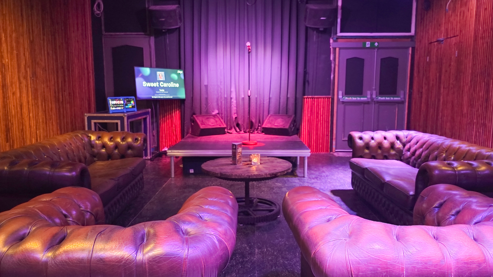 Stage with mic stand facing Chesterfield sofas