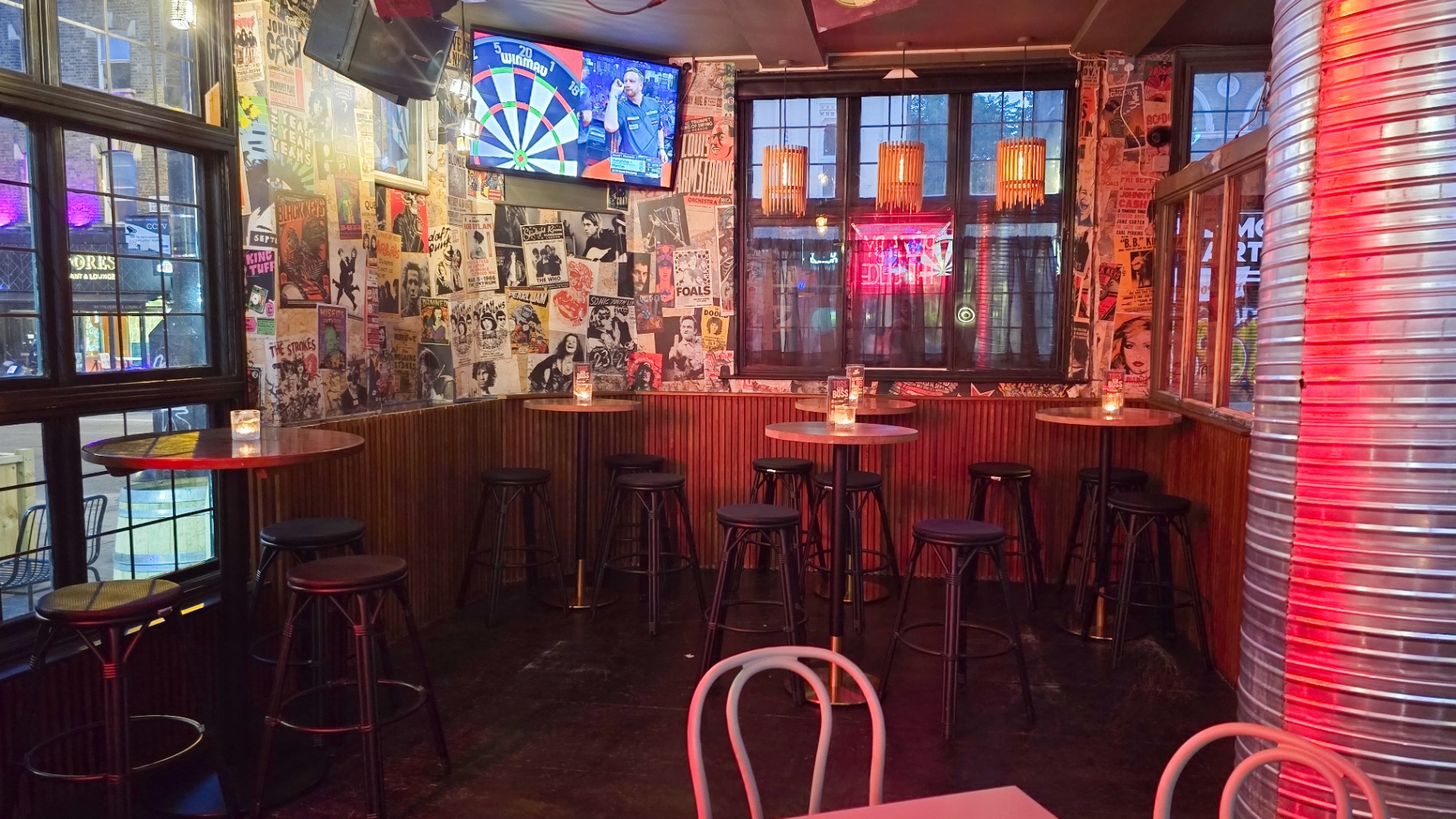 Poster-covered walls and stools by the window